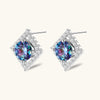 Diamond-shaped sterling silver stud earrings with rainbow moissanite centers surrounded by crystal halos