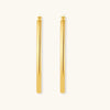 Set of geometric gold-plated sterling silver hoop earrings in oval and cushion shapes on cream background