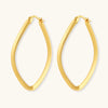 Set of geometric gold-plated sterling silver hoop earrings in oval and cushion shapes on cream background