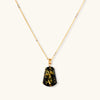 18k gold-plated necklace and earrings with green amber pendants featuring golden inclusions on cream background