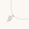 Abstract S-curve sterling silver pendant with zirconia accents on delicate chain against white background